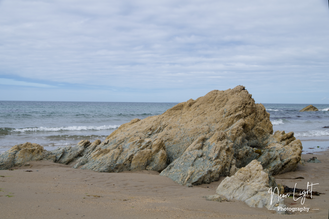 Rock Erupts Through the Sandy Beach