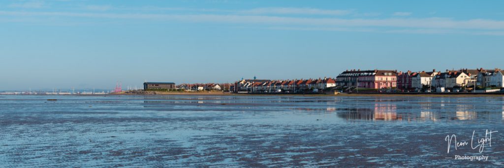 A blue winters sky reflects off the wet sand at low tide on Hoylake beach.